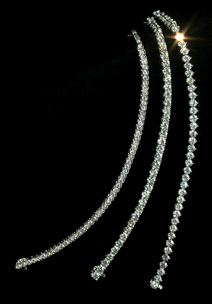 Three tennis bracelets with round cut diamonds, from left to right in semi bezel, four prong and two prong settings