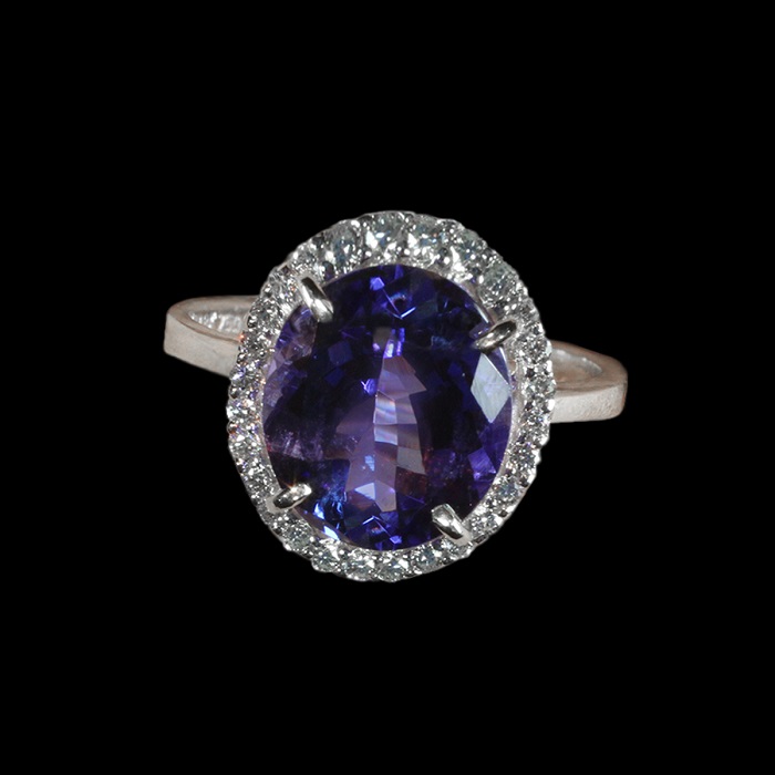 Halo style ring with oval shape tanzanite and round cut diamonds