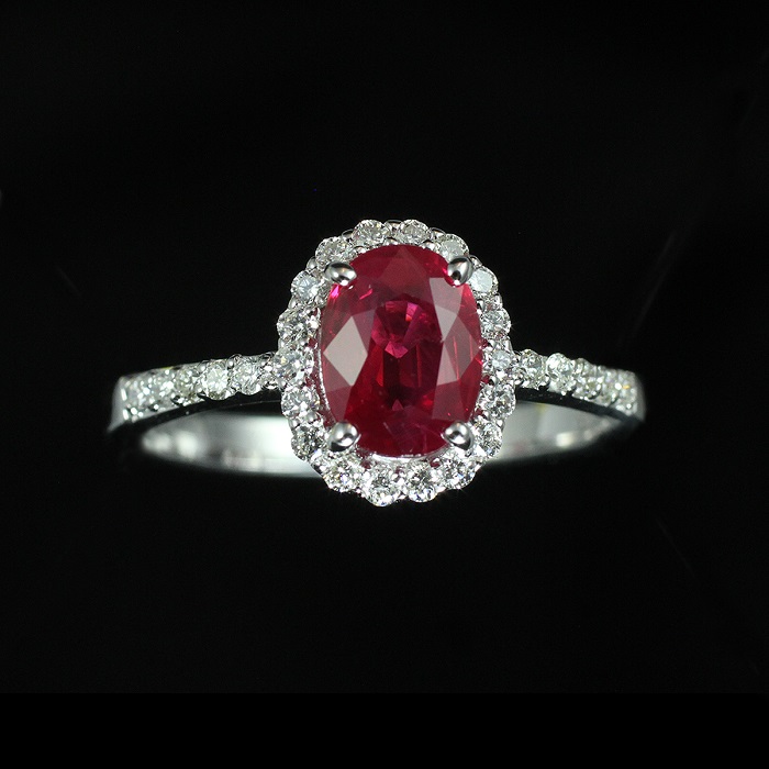 Halo style ring with oval shape ruby and round cut diamonds