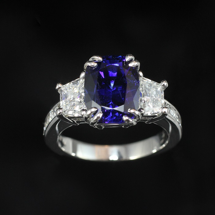 Cushion cut blue sapphire ring with trapezoid and princess cut diamonds